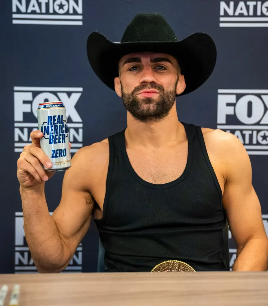 Bryce Meredith in a cowboy hat at a fight media table