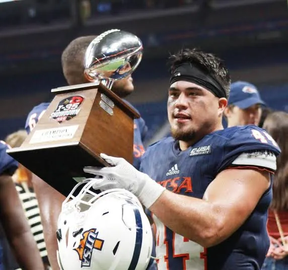 Les Maruo holding a trophy at UTSA
