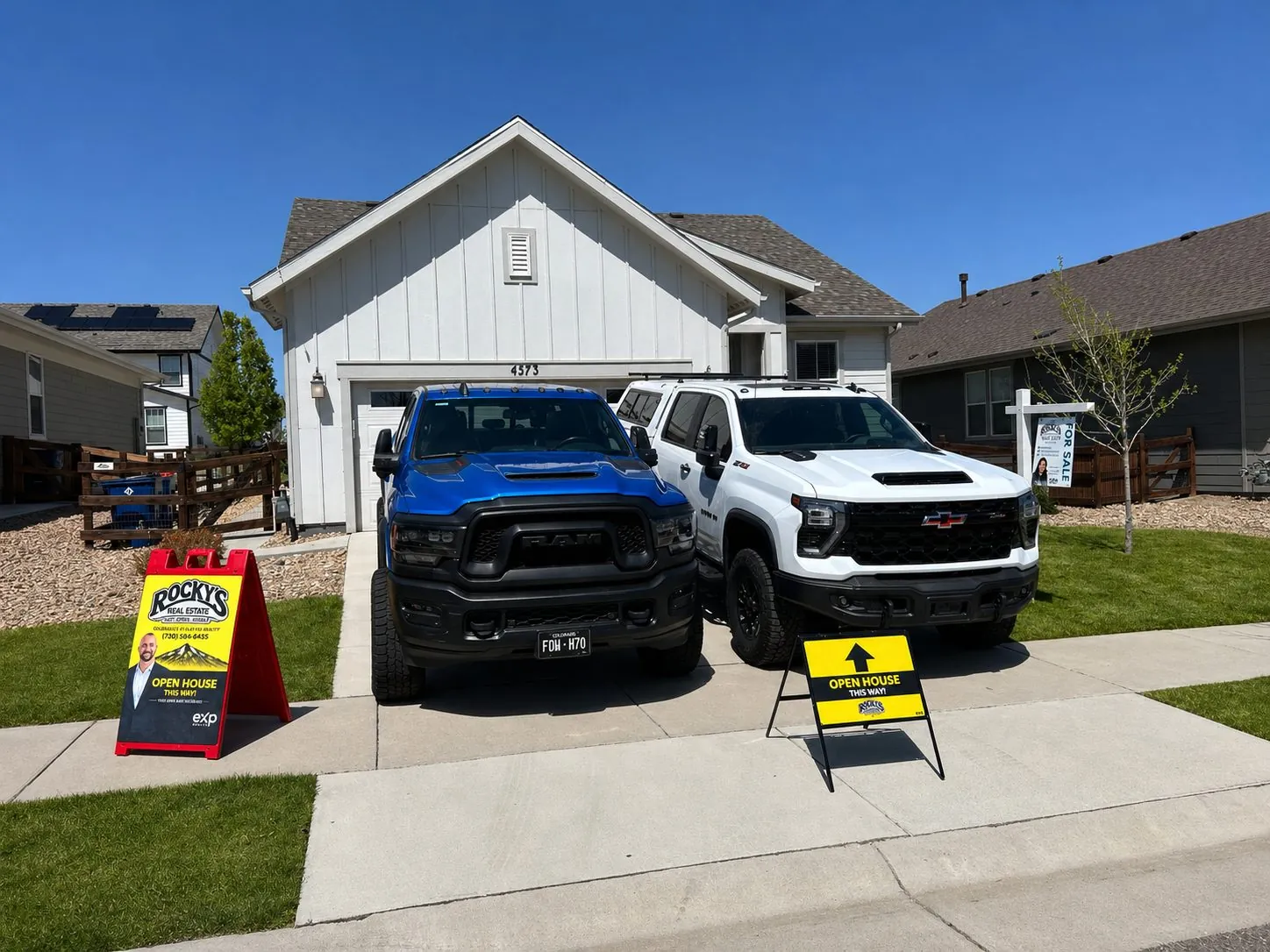Rocky's eXp open house with trucks parked in front of a Colorado listing